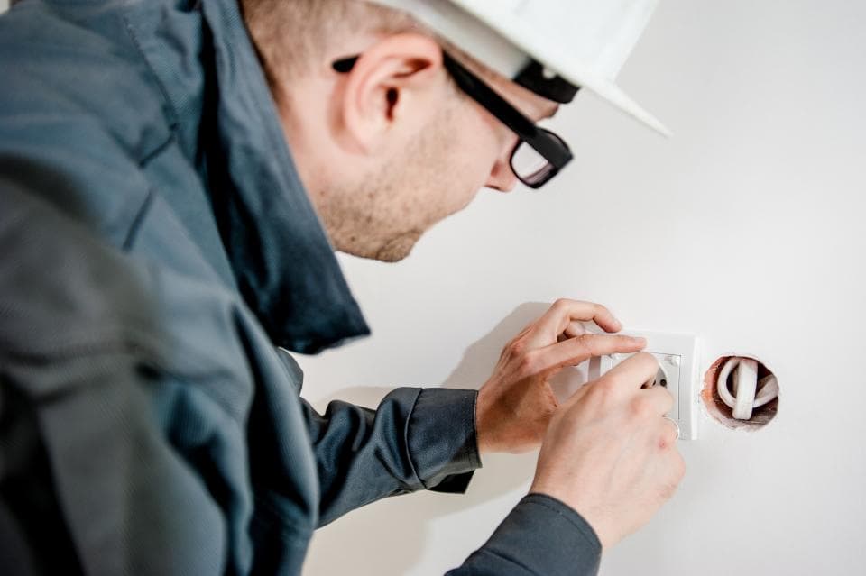 Un électricien installe une prise murale